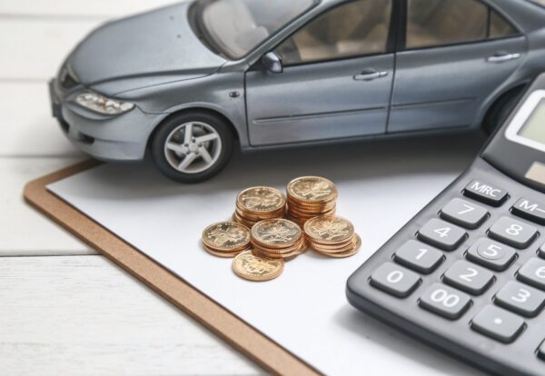 car model,calculator and coins on white table